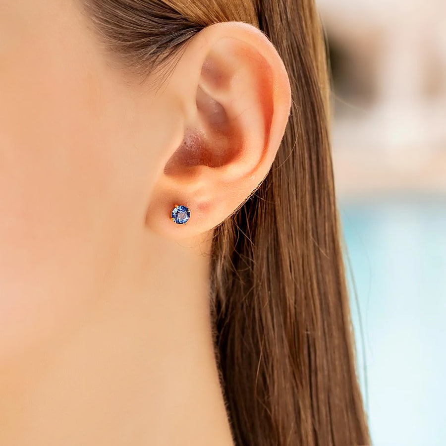 Blue sapphire screw back stud earring in 18K gold, worn on the ear, photo 1 of 3