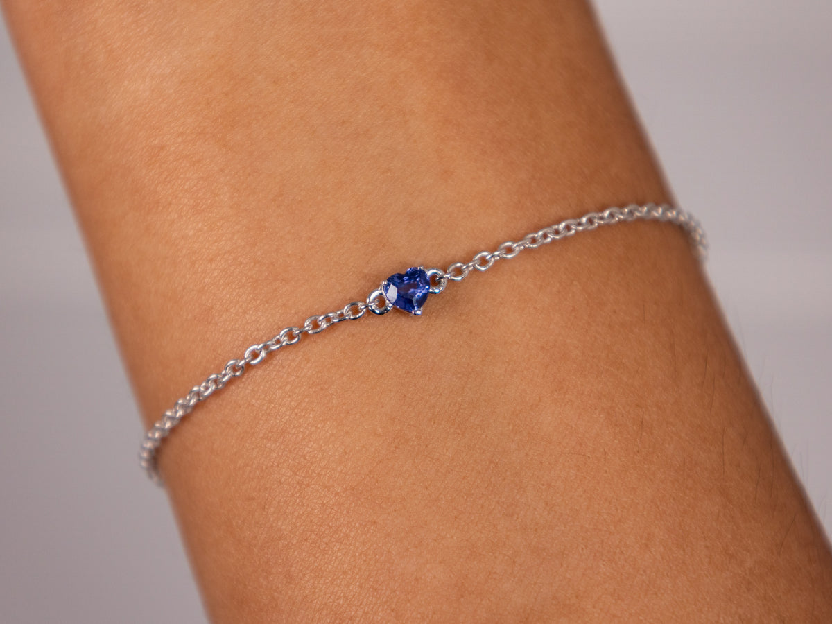 Blue sapphire heart bracelet worn on the wrist, 925 silver with white rhodium finish