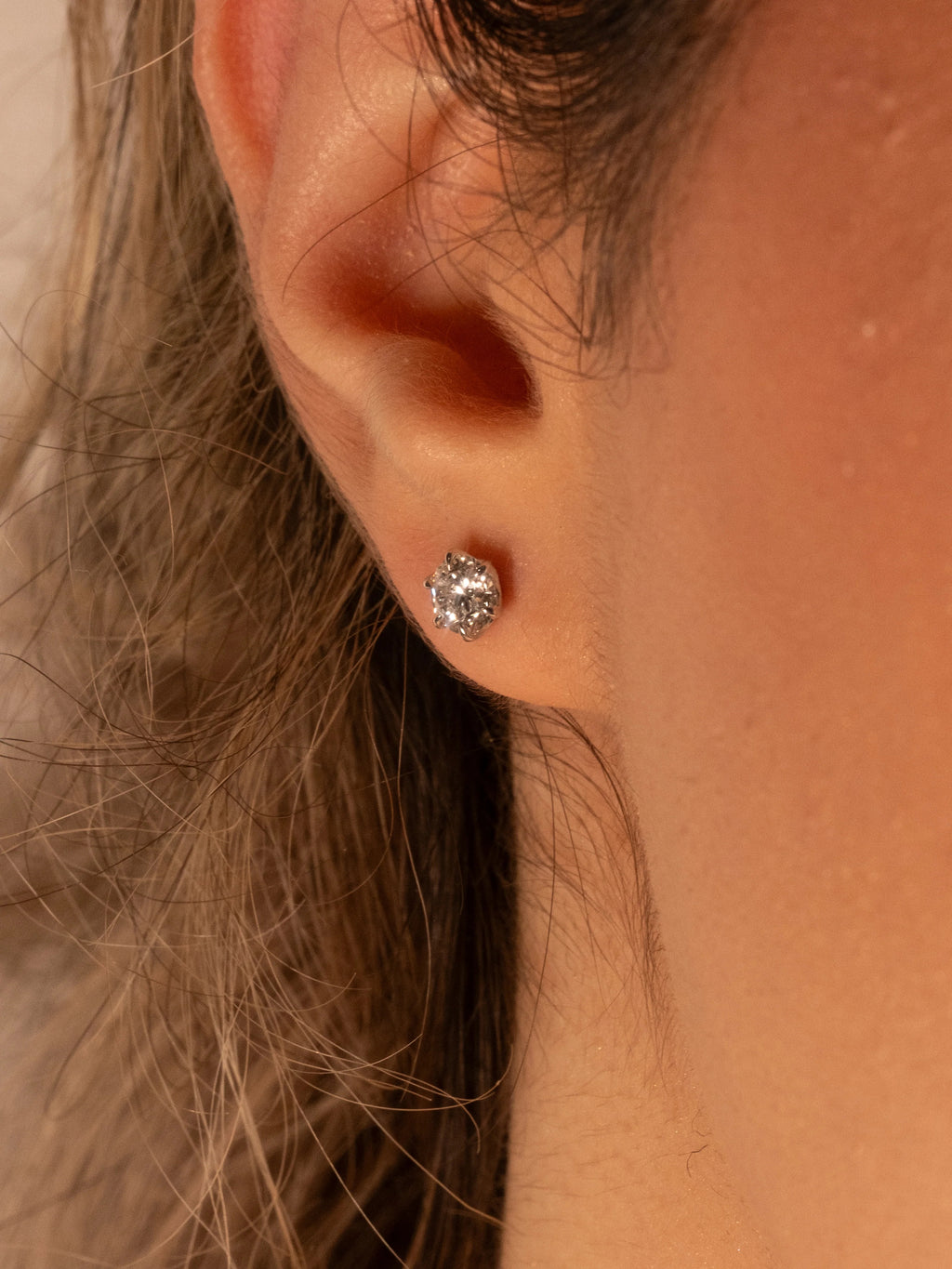 0.50 ct diamond stud in white rhodium worn on the ear, everyday size