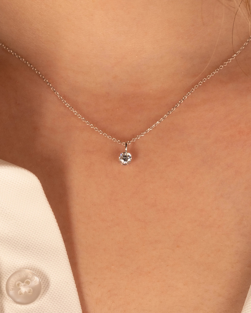 White rhodium 0.50 ct solitaire pendant on a 16 inch chain, worn at the collarbone