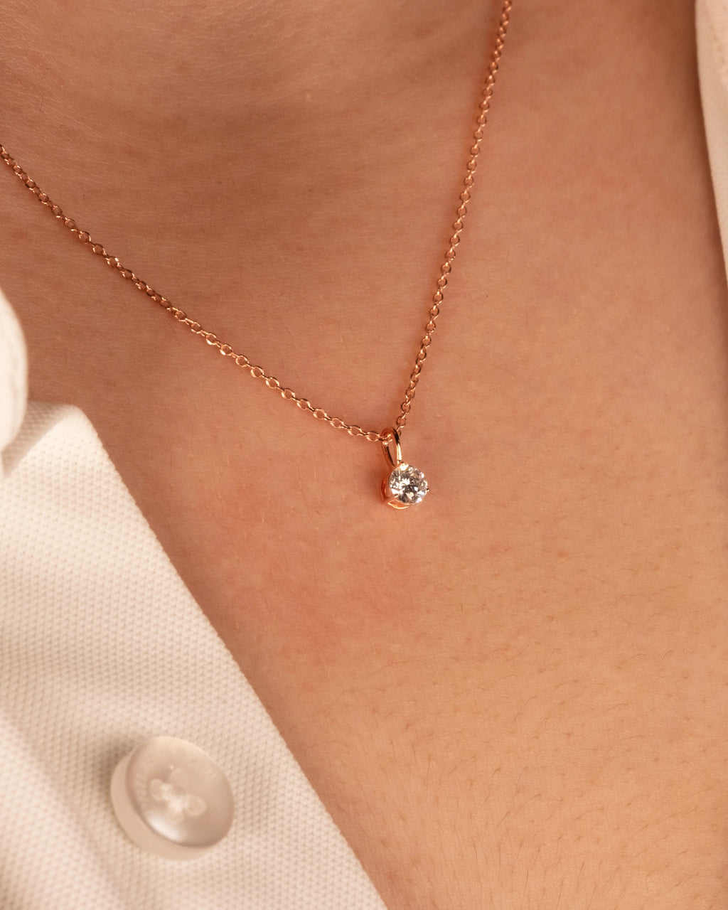Rose gold plated solitaire pendant worn at the collarbone