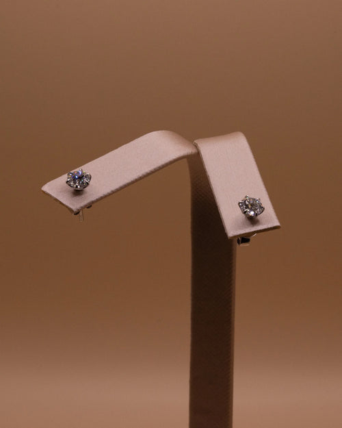 Pair of white rhodium diamond studs, 1 ct total, on an earring stand