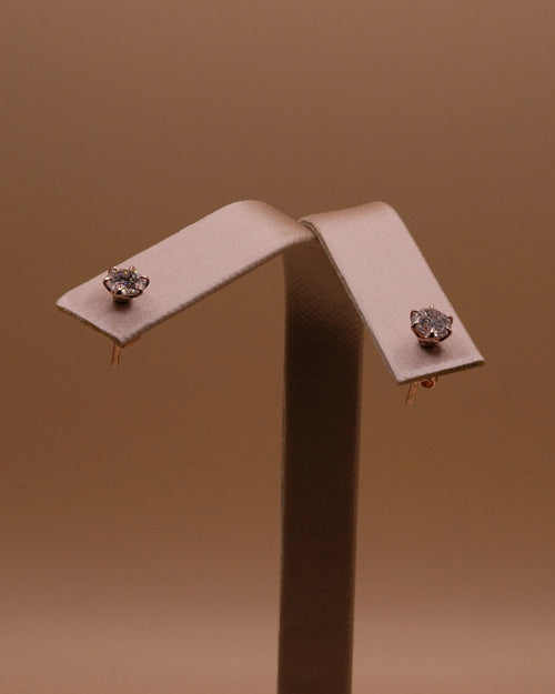 Pair of rose gold plated diamond studs on an earring stand