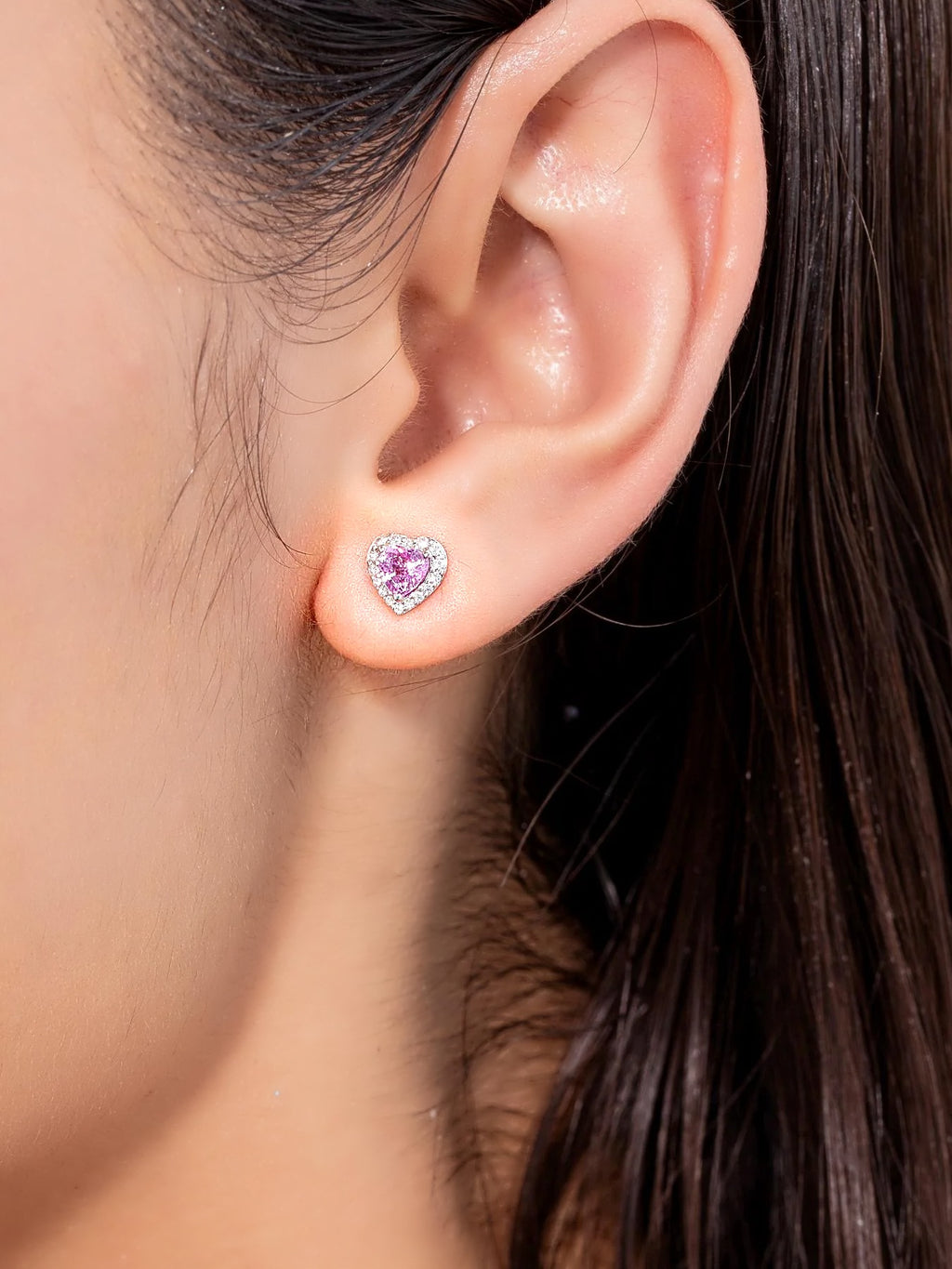 Pendiente de botón pequeño de corazón con zafiro rosa y diamantes en oro blanco de 18K, puesto en la oreja