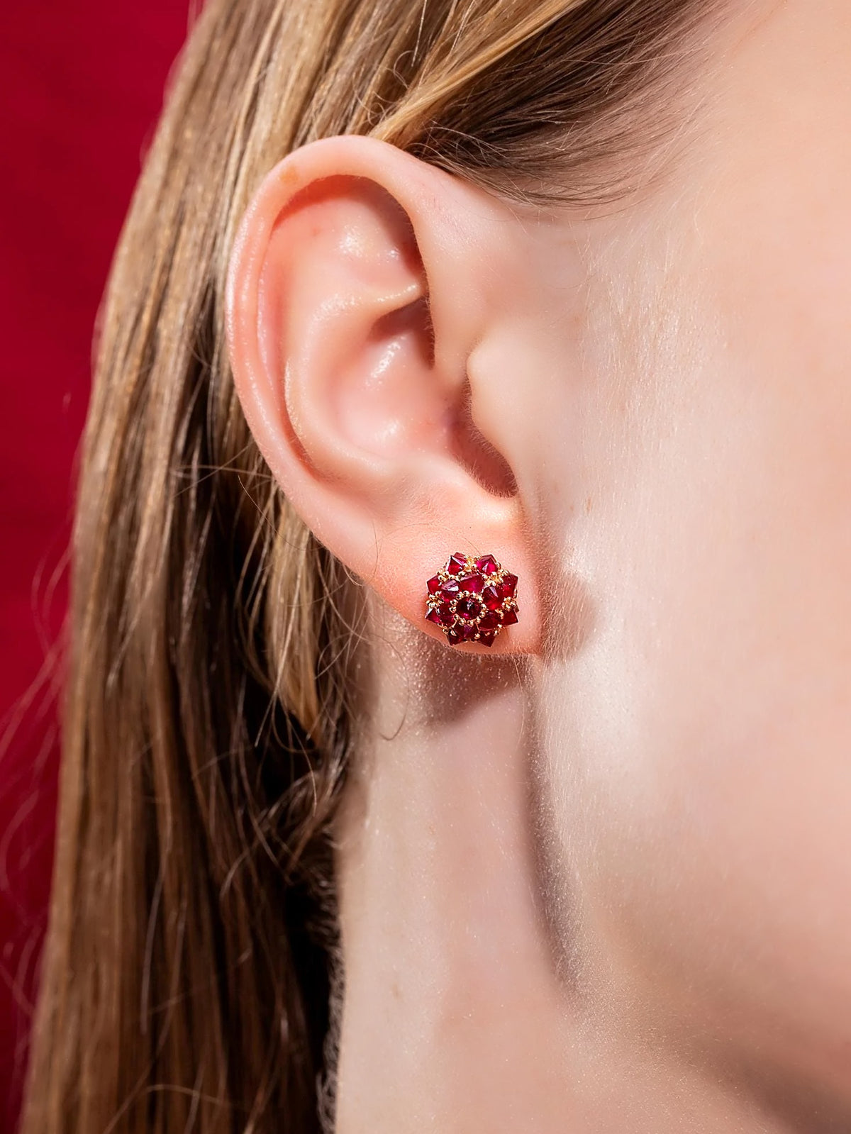 Ruby spike ball stud earring in 18K gold, worn on the ear