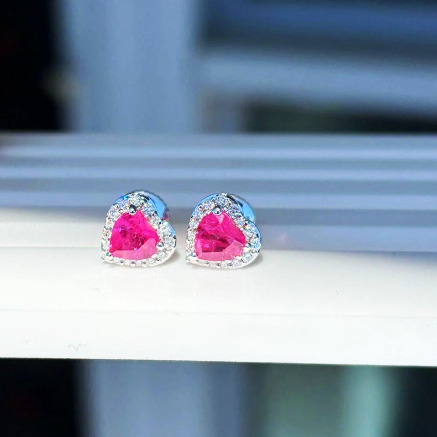 Boucles d'oreilles puces cœur halo saphir rose et diamants en or blanc 18K, sur un présentoir blanc