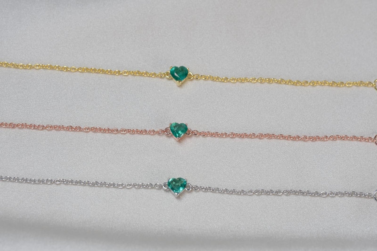 Natural emerald heart bracelet shown in yellow gold, rose gold and silver tone finishes