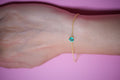 Faceted heart-cut emerald bracelet on the wrist with a dainty gold plated 925 silver chain