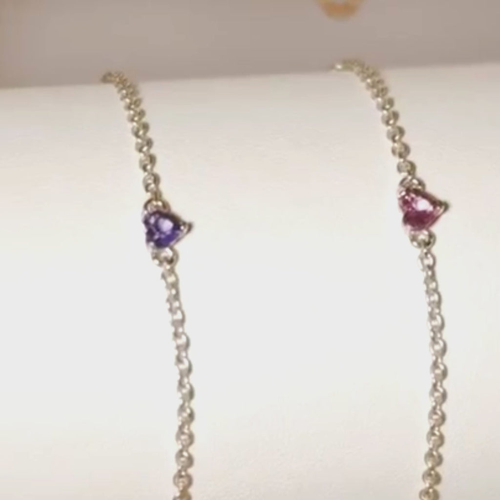 Sapphire heart bracelets in white rhodium, yellow gold and rose gold finish on a display