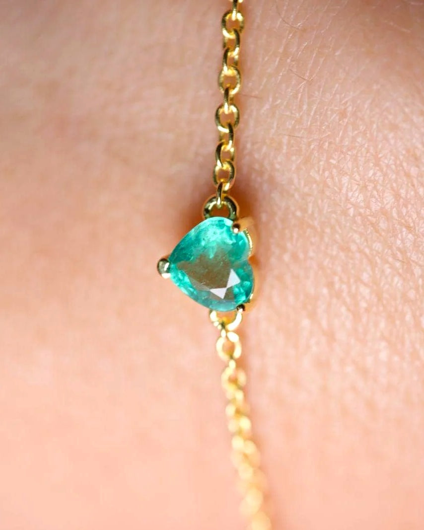 Close-up of the prong-set emerald heart on a dainty yellow gold plated sterling silver chain
