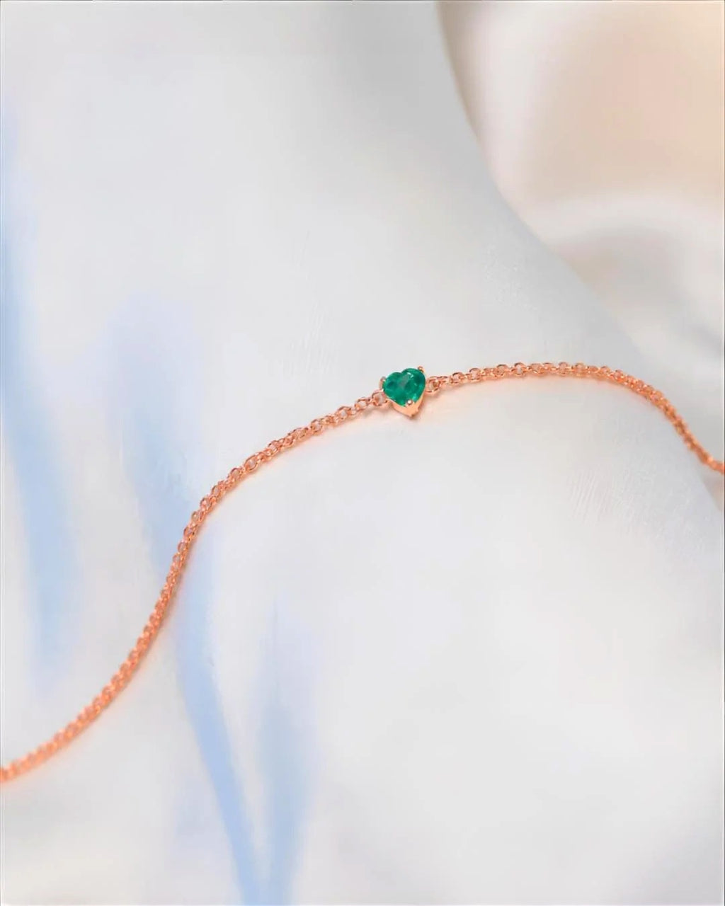 Rose gold plated sterling silver bracelet with a prong-set natural emerald heart