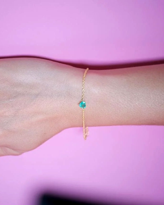 Minimalist emerald heart bracelet worn on the wrist, everyday gold plated sterling silver